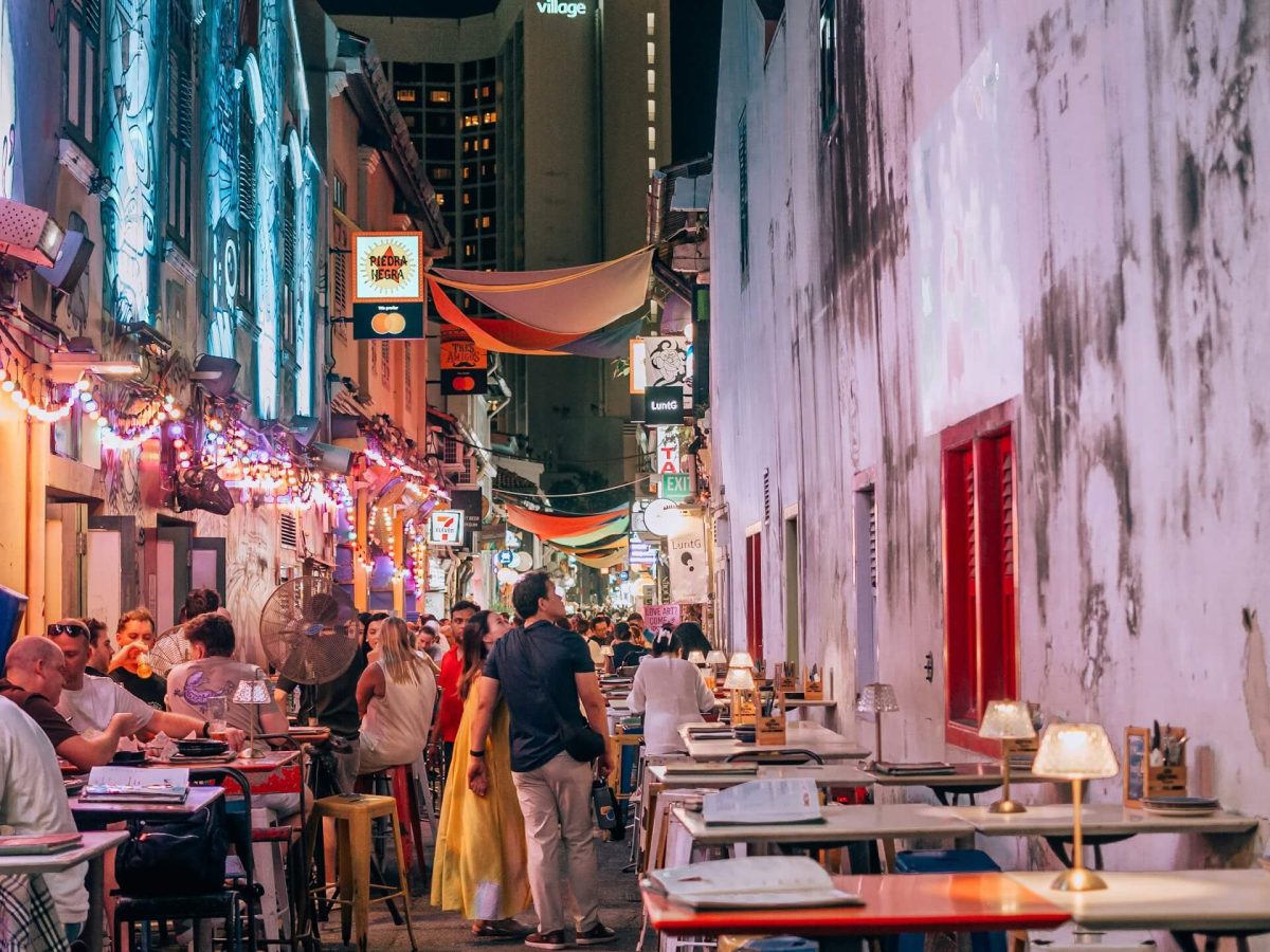 Colorful night scene of a lively street with outdoor dining in Singapore
